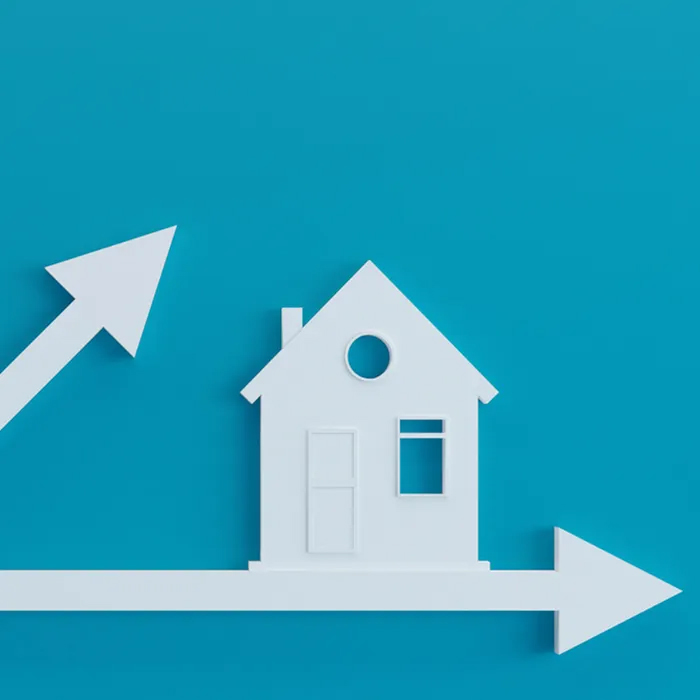 white icon of house and arrows with blue background.