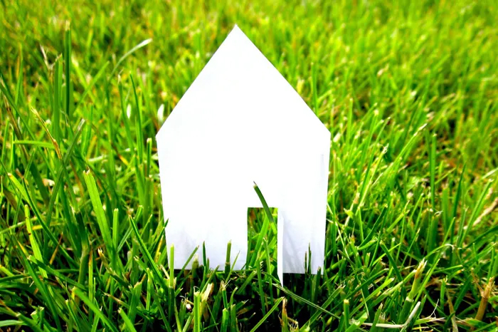 White shape of a house on green grass.